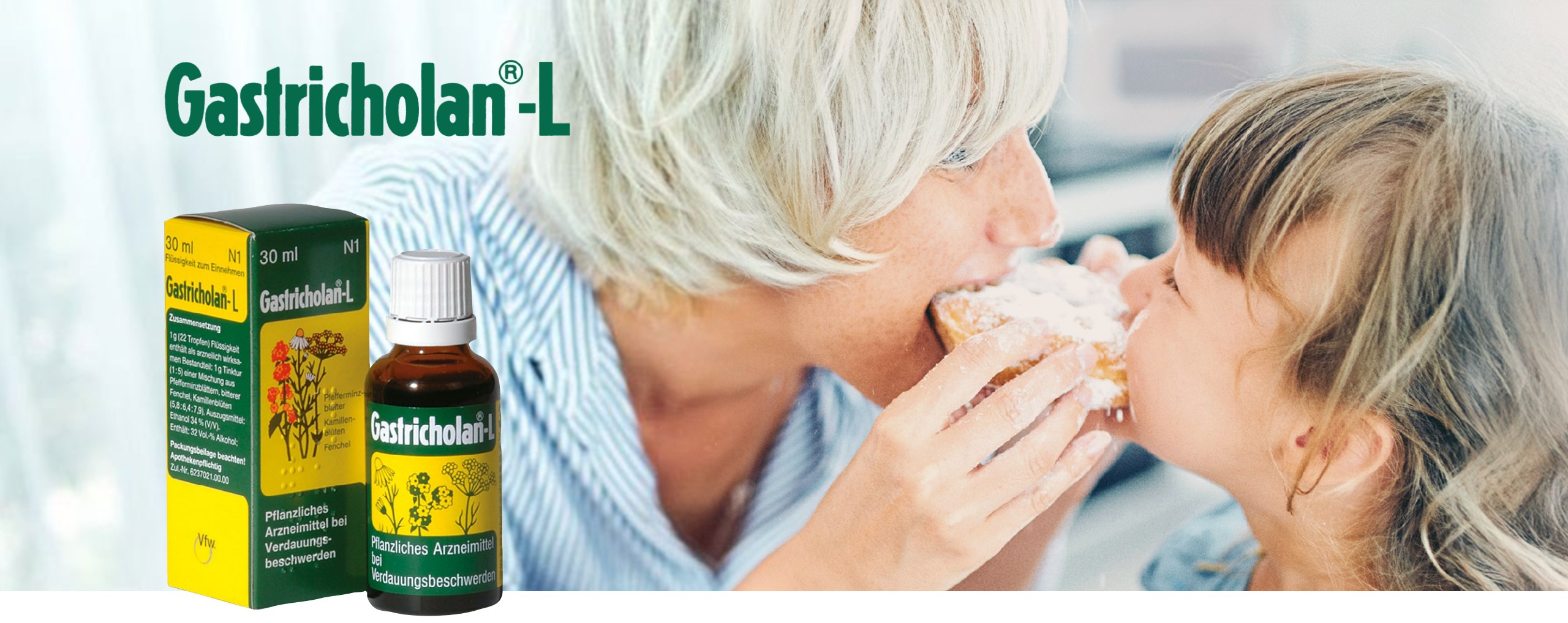 Gastricholan®-L – Faltschachtel und Flasche vor einer Großmutter, die mit ihrer Enkelin isst